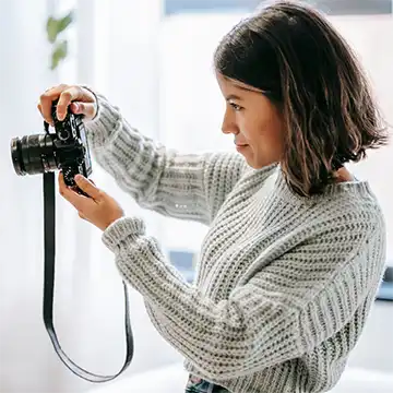 A woman taking pictures using an SLR type camera
