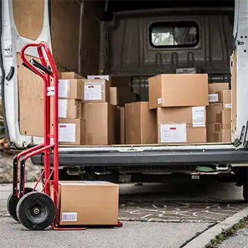 Boxes being loaded into the back of a delivery van.
