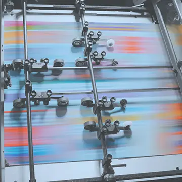 Close up of print machinery in use, with motion blur on the product being printed.
